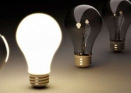 Row of lightbulbs, one in centre is lit, the rest are out.