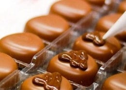 baker putting icing on chocolate